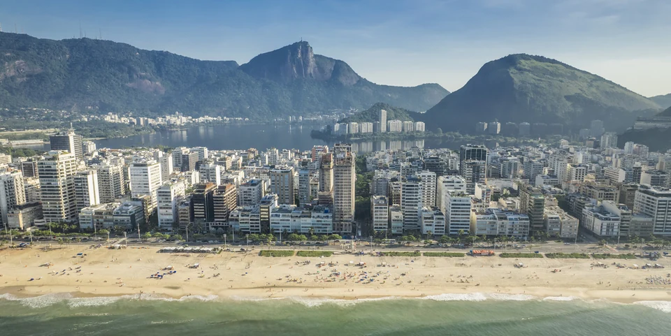 Panorama d’Ipanema avec plage, immeubles, lagune et montagnes, illustrant le quartier.